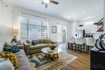 Peoria apartment for rent - a living room with a couch and a coffee table in front of a kitchen