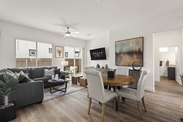 Liberty Hill apartment for rent - A living room with a grey couch, a wooden table and chairs, and a painting on the wall.