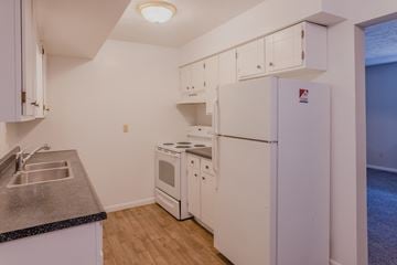 Omaha apartment for rent - a kitchen with white appliances and a sink and refrigerator