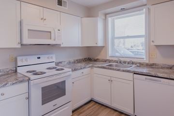 Omaha apartment for rent - a kitchen with white appliances and granite counter tops and a window