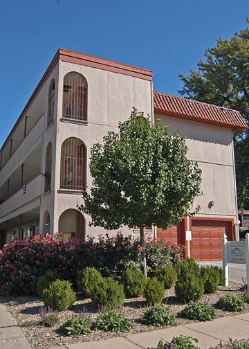 Omaha apartment for rent - a building with a tree and flowers in front of it