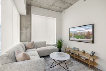 Victoria apartment for rent - A living room with a grey couch, a white coffee table, and a painting on the wall.