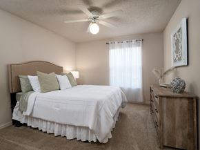 Pensacola apartment for rent - a bedroom with a large white bed and a ceiling fan at The Fountains Apartments, Pensacola, Florida, 32514
