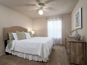 Gainesville apartment for rent - a bedroom with a large white bed and a ceiling fan at Tivoli Apartments, Gainesville, 32608