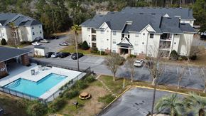 Pensacola apartment for rent - an aerial view of a swimming pool in front of an apartment building at The Fountains Apartments, Pensacola, FL