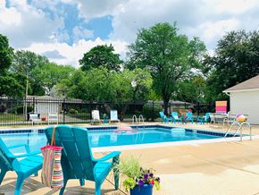 St. Charles apartment for rent - Outdoor pool with turquoise chairs and fence at Fox Run Apartments, St. Charles, Illinois
