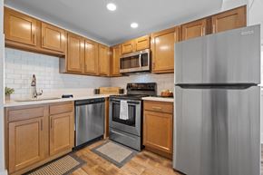 St. Charles apartment for rent - Corner kitchen with wood cabinetry and stainless appliances at Fox Run Apartments, St. Charles, IL 60174