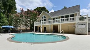 Acworth apartment for rent - the pool is in front of a large house with a porch