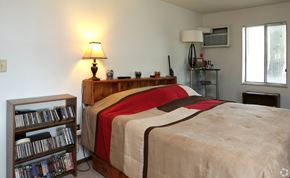 Cincinnati apartment for rent - a bedroom with a bed and a shelf with dvds