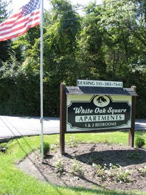 Cincinnati apartment for rent - a sign for white oak square apartments with an flag