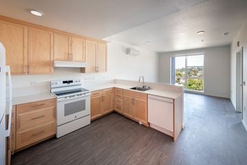 San Jose apartment for rent - A kitchen with wooden cabinets and a white stove top oven.