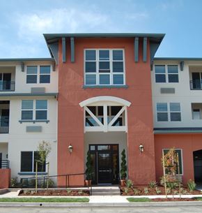 Santa Clara apartment for rent - A building with a red and white facade has a black door and windows.