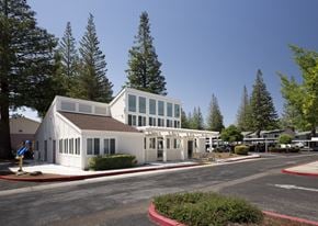 Campbell apartment for rent - A white building with a brown roof is surrounded by trees.