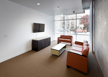 San Jose apartment for rent - A living room with brown carpet and a television on the wall.