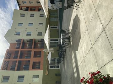 San Jose apartment for rent - A building with a white wall and a green wall with a red building in the background.
