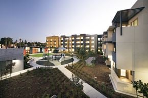 San Jose apartment for rent - A modern building complex with a courtyard and trees.