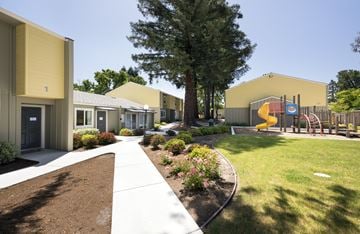 Mountain View apartment for rent - A playground with a slide and a yellow building in the background.