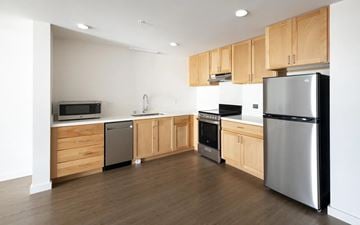 San Jose apartment for rent - A kitchen with wooden cabinets and stainless steel appliances.