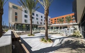 San Jose apartment for rent - A modern building with a courtyard and palm trees.