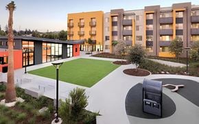 San Jose apartment for rent - A modern building with a palm tree in front.