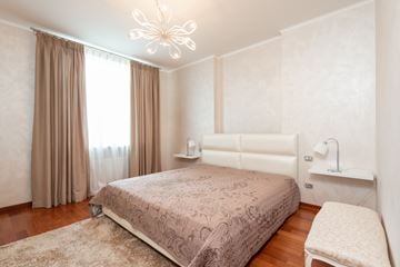 San Jose apartment for rent - A bedroom with a large bed and a chandelier.