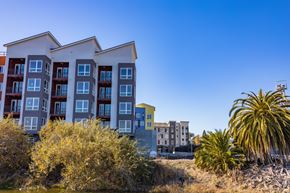 San Jose apartment for rent - A modern apartment building with a yellow accent building in the background.