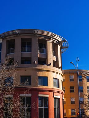 San Jose apartment for rent - A curved building with a balcony and a street light in front of it.