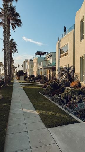 Santa Clara apartment for rent - A long walkway leads to a row of houses with a palm tree on the left.