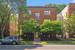 Minneapolis apartment for rent - a red brick building with a blue suv parked in front