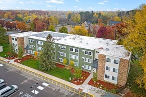 Mahtomedi apartment for rent - an aerial view of a building with a parking lot and trees