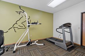 Minneapolis apartment for rent - a fitness room with a treadmill and weights on a wall