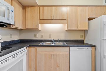 Vadnais Heights apartment for rent - A kitchen with wooden cabinets and white appliances.