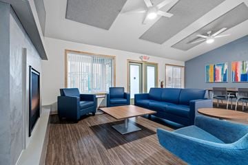 Mahtomedi apartment for rent - a living room with blue couches and chairs and a table