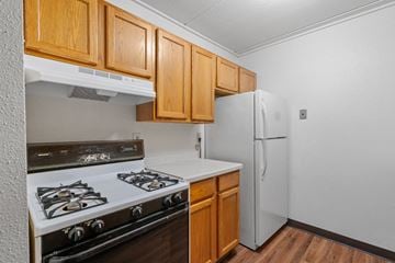 Anoka apartment for rent - a kitchen with white appliances and wooden cabinets and a refrigerator