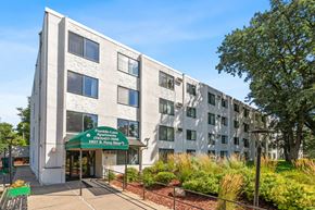 Anoka apartment for rent - a large building with a green sign in front of it