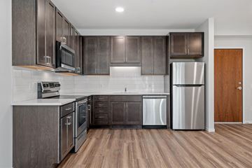 Minneapolis apartment for rent - a kitchen with stainless steel appliances and wooden cabinets