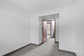 Minneapolis townhouse for rent - a bedroom with white walls and a door to a hallway with stairs