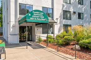 Anoka apartment for rent - the front entrance of a building with a green sign that reads