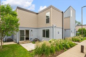 Minneapolis townhouse for rent - the front of a gray house with a sidewalk and grass