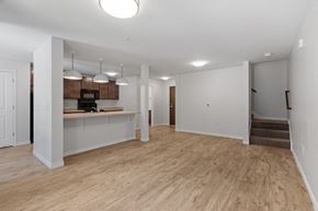 Minneapolis apartment for rent - an empty living room with a kitchen and stairs