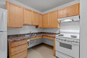Minneapolis townhouse for rent - a kitchen with white appliances and wooden cabinets