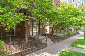 Minneapolis apartment for rent - a sidewalk in front of a brick building with trees
