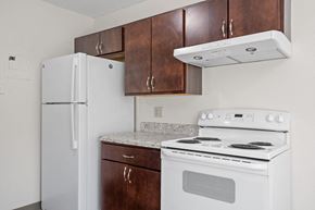 Eden Prairie apartment for rent - a kitchen with white appliances and wooden cabinets and a refrigerator