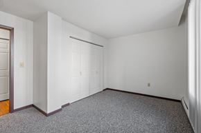 Hopkins apartment for rent - a bedroom with white walls and carpet and a white door