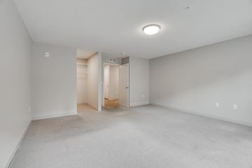 Minneapolis apartment for rent - a spacious living room with white carpet and a closet