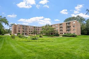 Roseville apartment for rent - a large brick apartment building with green grass and trees