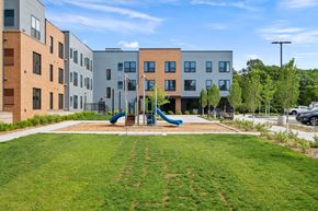 Elk River apartment for rent - A playground with a slide is in front of apartment buildings.
