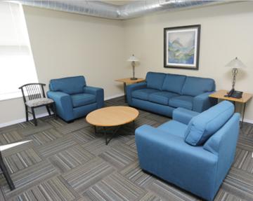 Minneapolis apartment for rent - A living room with blue furniture and a painting on the wall.