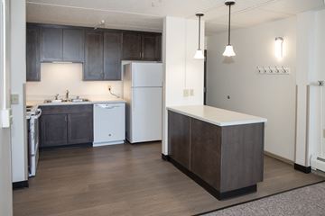 Minneapolis apartment for rent - a kitchen with white appliances and dark cabinets and a white counter top in a apartment