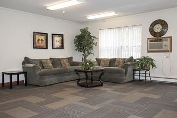 St. Paul apartment for rent - a living room with couches and a table and a clock on the wall